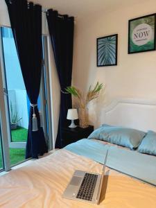 ein Schlafzimmer mit einem Bett und einem Laptop darauf in der Unterkunft Azure Condo Hotel Near Manila Ninoy Aquino International Airport in Manila