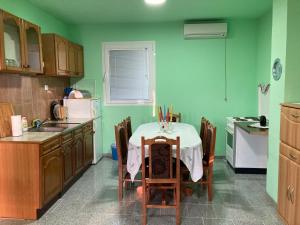 a kitchen with a table and a kitchen with green walls at Katina vikendica in Veliko Gradište