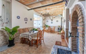 a dining room with a table and chairs at Nice Home In Trasmulas, Granada With 5 Bedrooms, Wifi And Outdoor Swimming Pool in Trasmulas