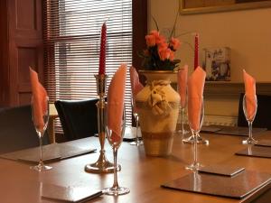 a table with wine glasses and a vase of flowers at Executive Serviced apartments 2 in Forfar