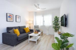 a living room with a blue couch and a table at Home2Book Stylish Apartment Alcalá Beach in Alcalá