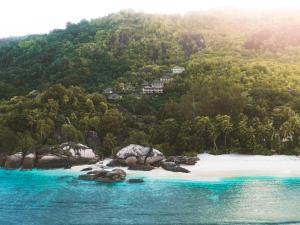 un'isola nell'oceano con una spiaggia e alberi di Valmer Resort and Spa a Baie Lazare Mahé