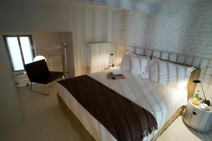 1 dormitorio con 1 cama blanca grande y 1 silla en Milan Design Suites, en Milán