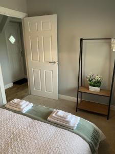a bedroom with a bed with a mirror and towels at 12 North Street in Sandwick