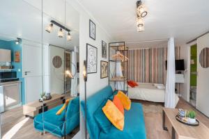 Una sala de estar con un sofá azul y una mesa. en L'Alexandrin, en Charleville-Mézières