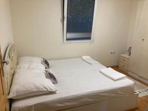 een bed met witte lakens en kussens in een slaapkamer bij Katina vikendica in Veliko Gradište