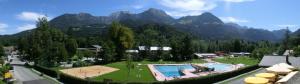 a resort with a swimming pool and mountains in the background at Hotel Brunneck in Schönau am Königssee