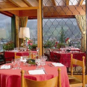 a dining room with a table with red table cloth at Hotel Catinaccio Rosengarten in Moena +16 photos