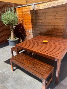 une table et un banc en bois avec une plaque jaune dans l'établissement Superbe logement près de Bruxelles avec spa privé, à Bruxelles