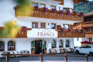 a building with a balcony with flowers on it at Garni Hotel Franca b&b in Selva di Val Gardena