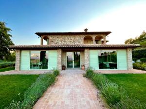 una casa con un camino de ladrillo delante de ella en Agriturismo Fattoria di Monticello, en San Venanzo