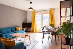 - un salon avec un canapé bleu et une table dans l'établissement Les chambres du Vercors - Parking Free Fibre Netflix, à Fontaine