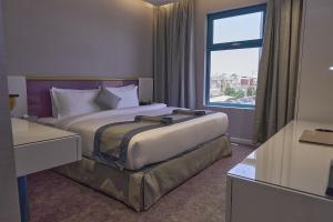 a hotel room with a bed and a large window at Marvelous Hotel in Tabuk