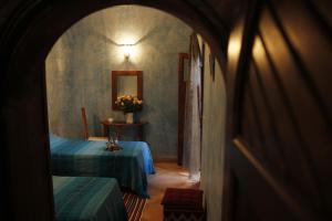 un pasillo con 2 camas y una mesa con flores en Riad Azenzer, en Marrakech