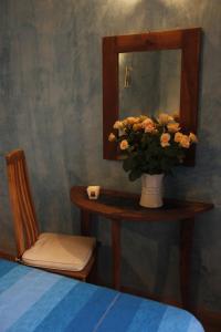 una mesa con un jarrón de flores y un espejo en Riad Azenzer en Marrakech