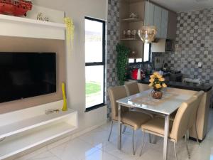 a kitchen with a table and chairs and a television at Diversão, férias, casa na praia de cumbuco. in Caucaia