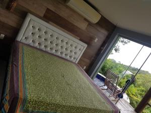 ein Schlafzimmer mit einem Bett und einem großen Fenster in der Unterkunft Villas do Pratagy Com Jacuzzy Prive Bromelia 301 in Maceió