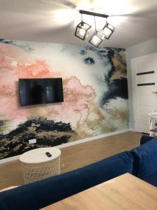 un soggiorno con divano e TV a parete di Apartament 15G a Skawina