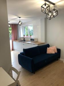 un soggiorno con divano blu e una cucina di Apartament 15G a Skawina