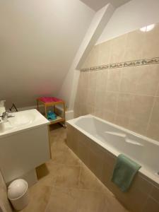 a bathroom with a bath tub and a sink at Grande Maison familiale proche mer 10personnes in Auberville-la-Manuel