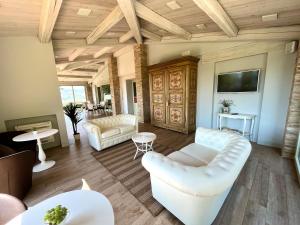 salon z białymi meblami i telewizorem z płaskim ekranem w obiekcie Agriturismo Fattoria di Monticello w mieście San Venanzo