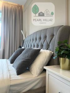 un letto con due cuscini sopra in una stanza di Tanjung Bungah PEARL HILL42 Homestay a Tanjung Bungah
