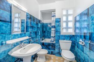 uma casa de banho em azulejos azuis com um WC e um lavatório em Le Marignan- Studio plein centre em Cassis