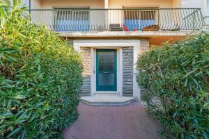 ein Gebäude mit einer blauen Tür und einem Balkon in der Unterkunft Le Marignan- Studio plein centre in Cassis