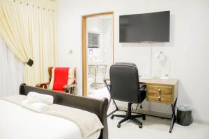 sypialnia z łóżkiem, biurkiem i krzesłem w obiekcie Pitikwe Hill Guesthouse w mieście Lobatse