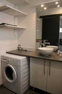 uma cozinha com uma máquina de lavar roupa e um lavatório em La petite maison by PÓM em Lorient