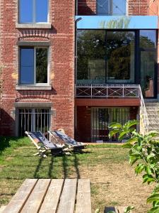 two lounge chairs on the grass in front of a building at Maison Henri Namur in Namur