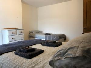 1 dormitorio con 2 camas y toallas. en Sweet Caroline at Longton. Great location for Stoke on Trent, The Potteries and Alton Towers. en Longton