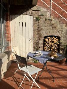 a table and chair on a patio with a fireplace at Maison Henri Namur in Namur