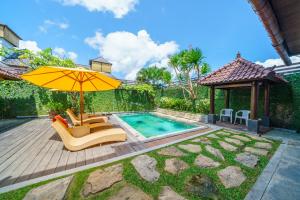 a backyard with a swimming pool and an umbrella at Black Pearl Hostel in Canggu