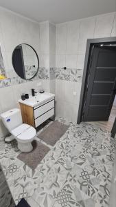 a bathroom with a toilet and a sink and a mirror at Panorama Hotel & SPA in Chernivtsi