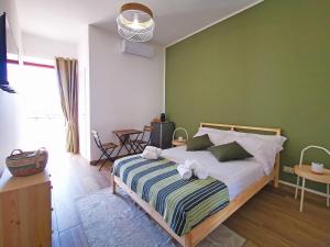 1 dormitorio con 1 cama con pared verde en Pasitea, en Bagheria