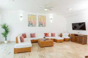 sala de estar con sofá y TV en Grand Laguna Beach Properties by Calisto Stays, en Sosúa