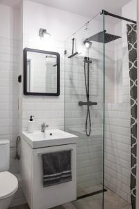La salle de bains est pourvue d'un lavabo et d'une douche avec un miroir. dans l'établissement ClickTheFlat Jasna Palace of Culture Apart Rooms, à Varsovie