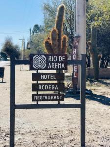 a sign in the middle of a desert with a cactus at Estancia Rio de Arena 