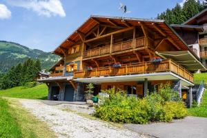 Cette grande maison en bois dispose d'un balcon sur une montagne. dans l'établissement Chalet CLEMALOU 14-16 personnes avec jacuzzi, à Châtel