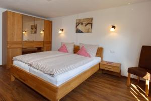 a bedroom with a bed and a chair at Ferienwohnung Adlerhügel in Ruhpolding