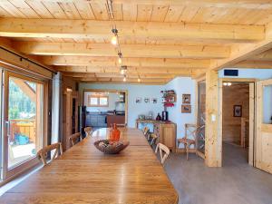 Cette chambre comprend une grande table en bois et une cuisine. dans l'établissement Chalet CLEMALOU 14-16 personnes avec jacuzzi, à Châtel