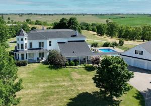  Elle offre une vue aérienne sur une grande maison blanche dotée d'une piscine. dans l'établissement Wildflower Ranch Inn, à Springfield