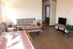 een woonkamer met een bank en een tafel bij Runada B&B in Sisian
