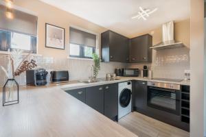 cocina con armarios negros y lavavajillas en Waterlily Apartment - Beautiful 1-bed with overlooking balcony, en Nottingham