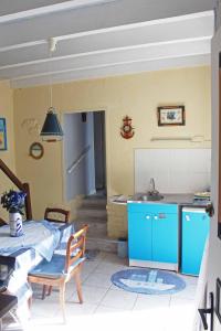 a kitchen with blue cabinets and a table with a sink at Chez Martine et Bernard in Saint-Vincent-Sterlanges