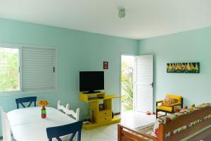 een woonkamer met een tafel en een televisie bij Casa aconchegante na praia da Daniela in Florianópolis