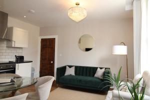 a living room with a green couch and a table at Sterling House @ Short Stays in Basingstoke