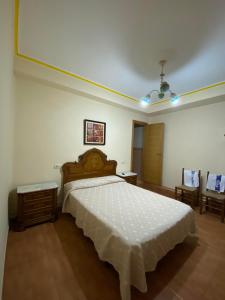 1 dormitorio con 1 cama grande con colcha blanca en PENSIÓN SANTA CLARA, en Pontevedra