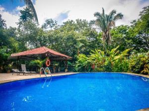 una gran piscina azul con cenador en Casa Colores, en Montezuma